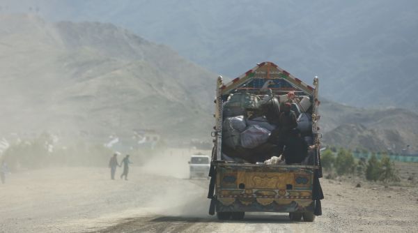A truck driving on a dusty road