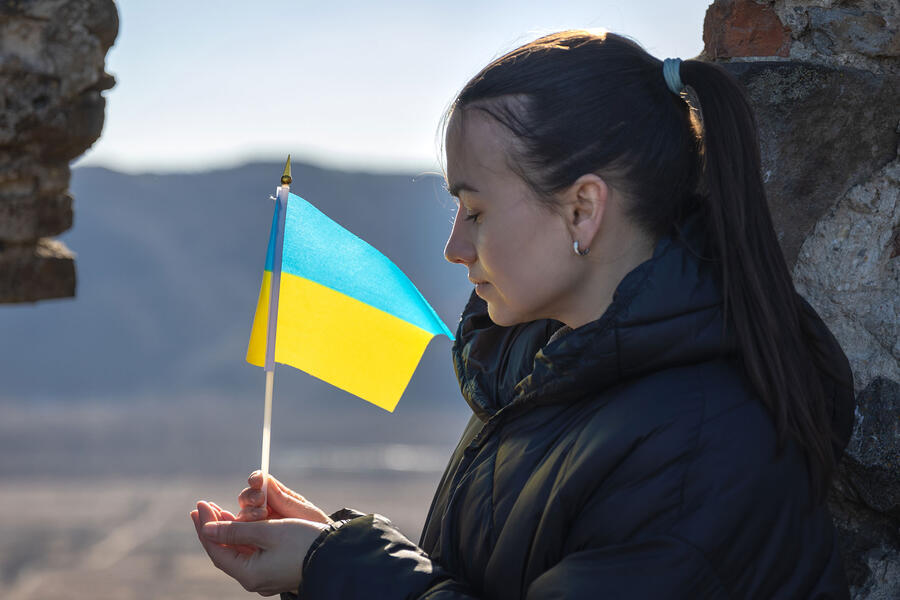 A young woman with the flag of Ukraine in her hands
