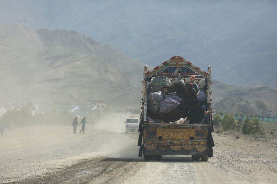 A truck driving on a dusty road